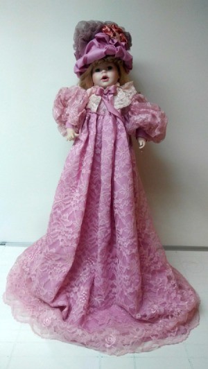 Identifying a Porcelain Doll - doll wearing a long pink dress and matching hat