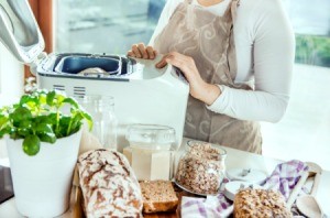 Woman making bread in a bread machine.