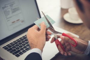 A man cutting up his credit cards.