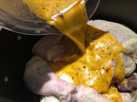 pouring sauce on Chicken