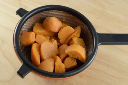 A strainer with canned yams.