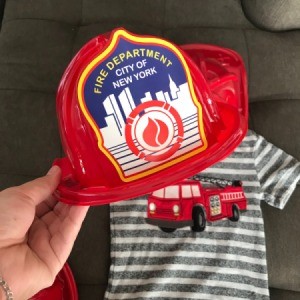 A fire fighter hat next to a fire truck themed t-shirt.