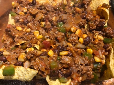 adding beef mixture to chips