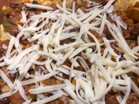 adding grated cheese to casserole