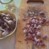 A cutting board full of very small garlic cloves.