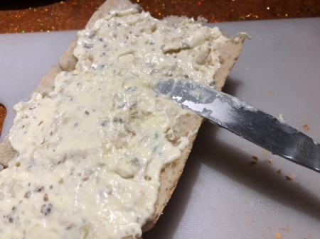 spreading garlic butter on bread