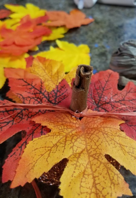 Dollar Tree Tiny Scrubber Pumpkins - closeup of the leaves placed around the cinnamon stick