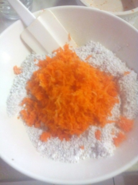 adding grated carrot to dry ingredients