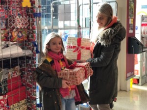 A mother and child choosing gifts from a donation site.