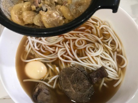 A bowl of soup with the broth strained before being added.