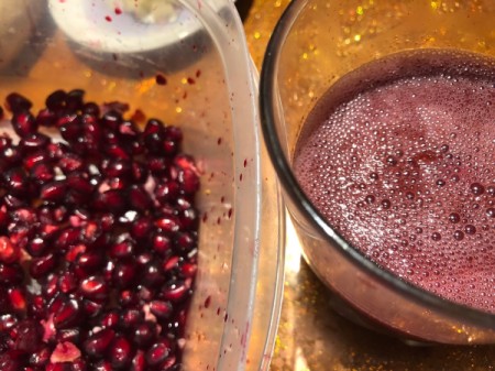 Pomegranate seeds and bowl of juice