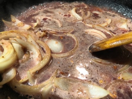 mixing sauce and onions in pan