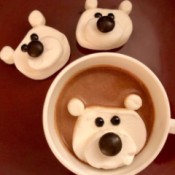 Marshmallow Polar Bears - two finished bears next to a cup of chocolate with a floating, melting polar bear