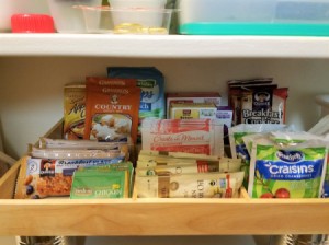 A shadowbox frame storing small packets in a pantry.