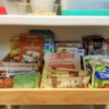 A shadowbox frame storing small packets in a pantry.