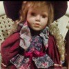 Identifying a Porcelain Doll - doll wearing wine colored dress and matching hat with a floral vest