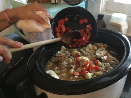 adding chopped red pepper to pot