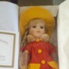 Value of a Heritage Signature Collection Porcelain Doll - doll wearing a red and yellow raincoat