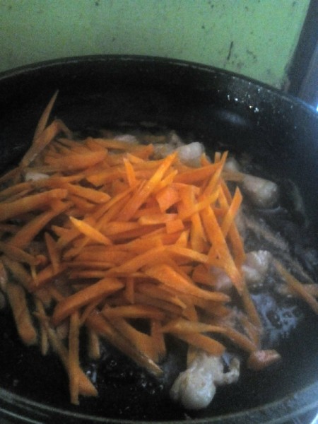 adding grated carrot to pan