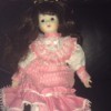 Identifying a Porcelain Doll - dark haired doll wearing a pink dress