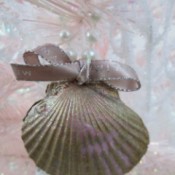 Shabby Chic Shell Ornaments - closeup of ornament with a tiny bow handing in a pink and white tree
