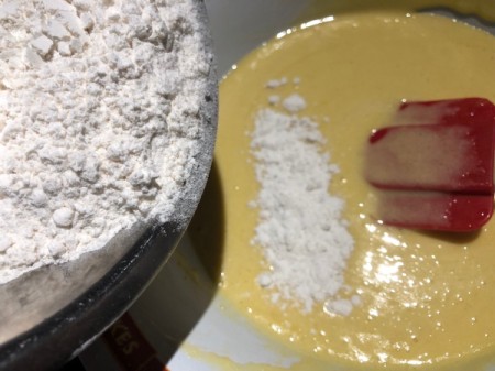 adding flour to batter
