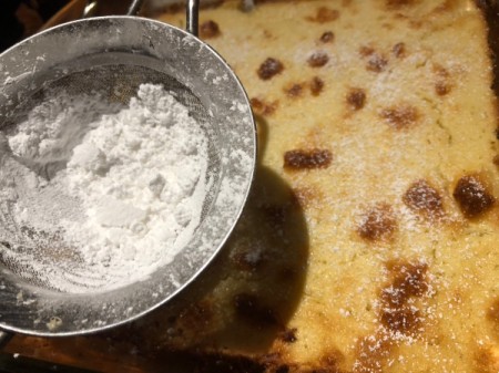 sprinkling powdered sugar on cake