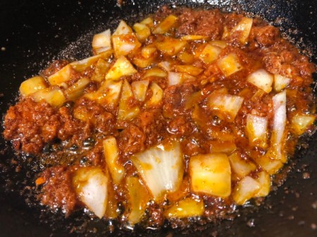 adding onion to Chorizo in pan