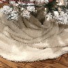 A blanket being used as a Christmas tree skirt.