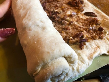 rolling up Cinnamon Rolls