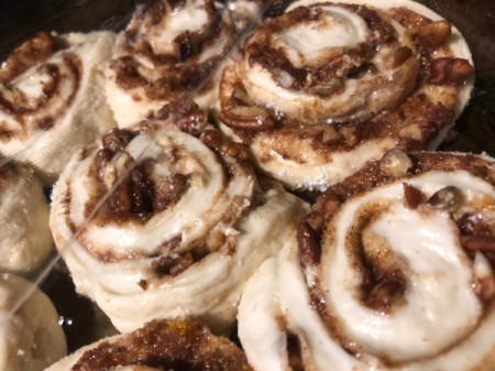placing cinnamon rolls on baking tray