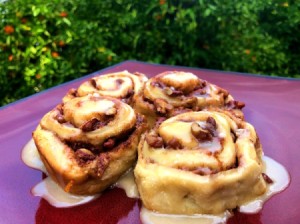 Orange Pecan Cinnamon Rolls on table by orange tree