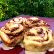 Orange Pecan Cinnamon Rolls on table by orange tree