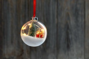 Clear Christmas ornament filled with tree, snow and a present.