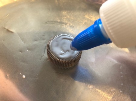 Plastic Bottle Cap Ornaments - add white glue to all areas where you would like glitter