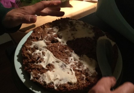 adding frosting to middle of  Carrot Cake