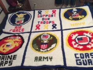 A large crocheted wall hanging with a military theme.