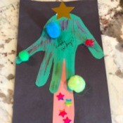 Christmas Tree Card Made by a Toddler - finished card with pom poms added to the tips of fingers and on the palm of the hand