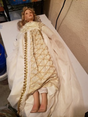 Identifying a Porcelain Doll - doll wearing a long white dress with gold trim