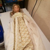 Identifying a Porcelain Doll - doll wearing a long white dress with gold trim