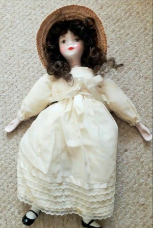 Identifying a Porcelain Doll - doll wearing a period long white dress and a straw hat