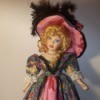 Identifying a Porcelain Doll - doll wearing a long floral dress with a dark pink under skirt and matching hat