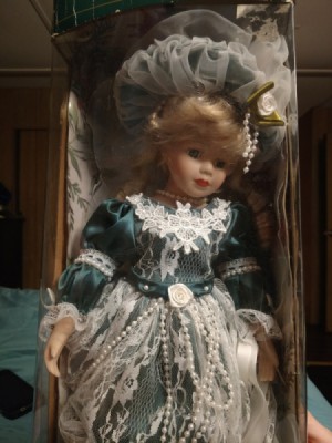 Identifying a Porcelain Doll - doll in box wearing a dark green dress with lace and pearls