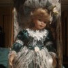 Identifying a Porcelain Doll - doll in box wearing a dark green dress with lace and pearls