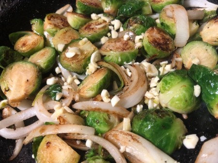adding spices and garlic to Brussels Sprouts