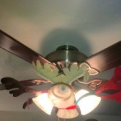 A ceiling fan decorated with reindeer antlers.