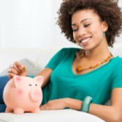 Woman putting money in a piggy bank.