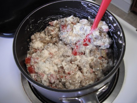 adding cream cheese & Rotel to sausage in sauce pan