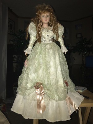 Identifying a Porcelain Doll  - doll wearing a long with dress with ribbon roses