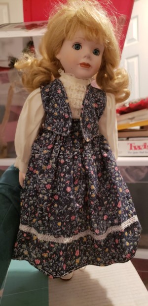 Identifying a Porcelain Doll - doll wearing a floral print skirt and vest